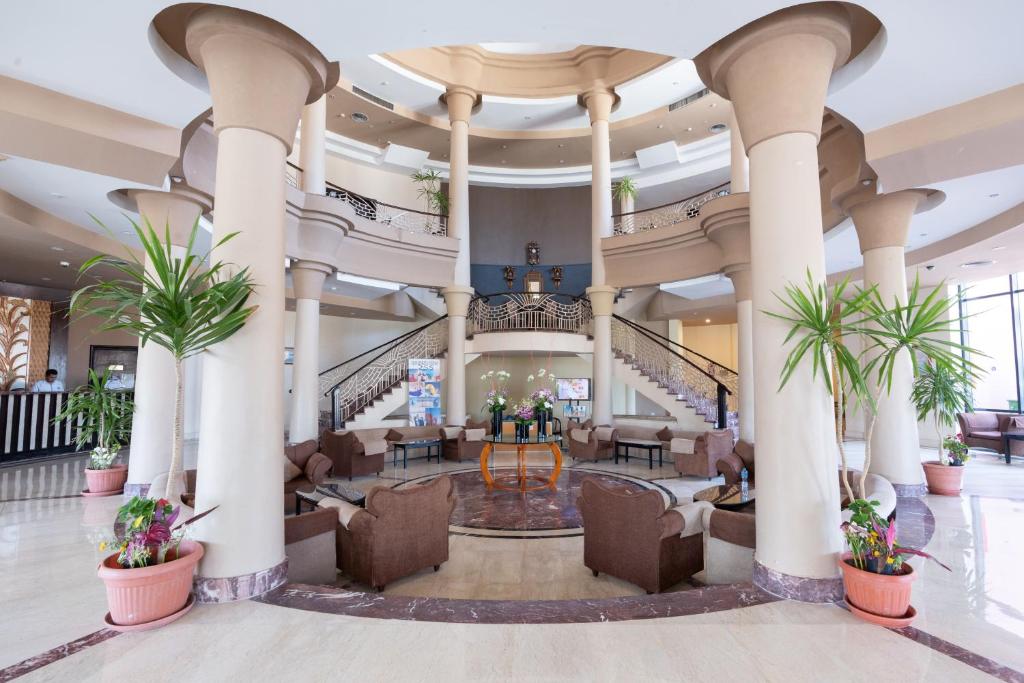a lobby of a hotel with palm trees at Parrotel Aqua Park Resort in Sharm El Sheikh