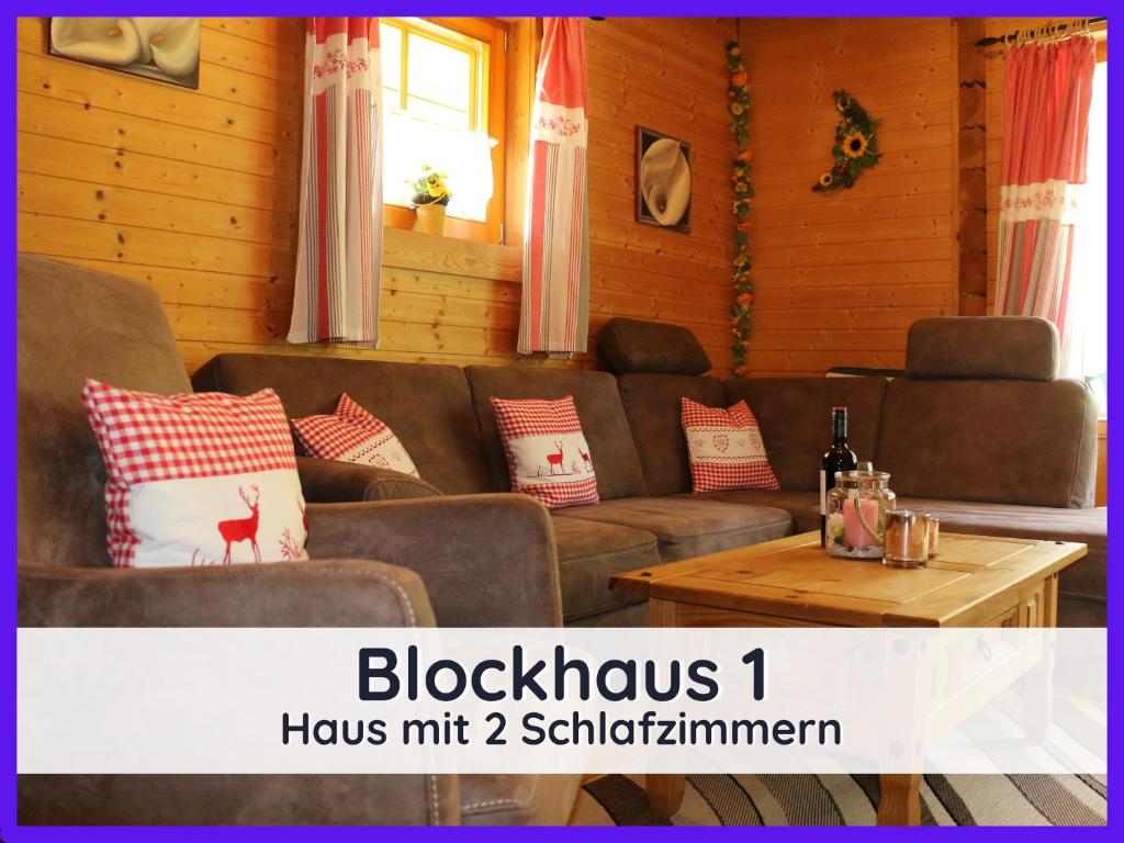 uma sala de estar com um sofá e uma mesa em Der Fuchsbau - 3 separate Blockhäuser - ruhige Lage - 50m bis zum Wald - eingezäunter Garten em Bad Sachsa