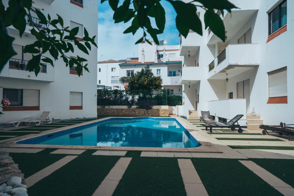 a swimming pool in the courtyard of a building at Apartamento Deluxe Oldtown 30 by Umbral in Albufeira