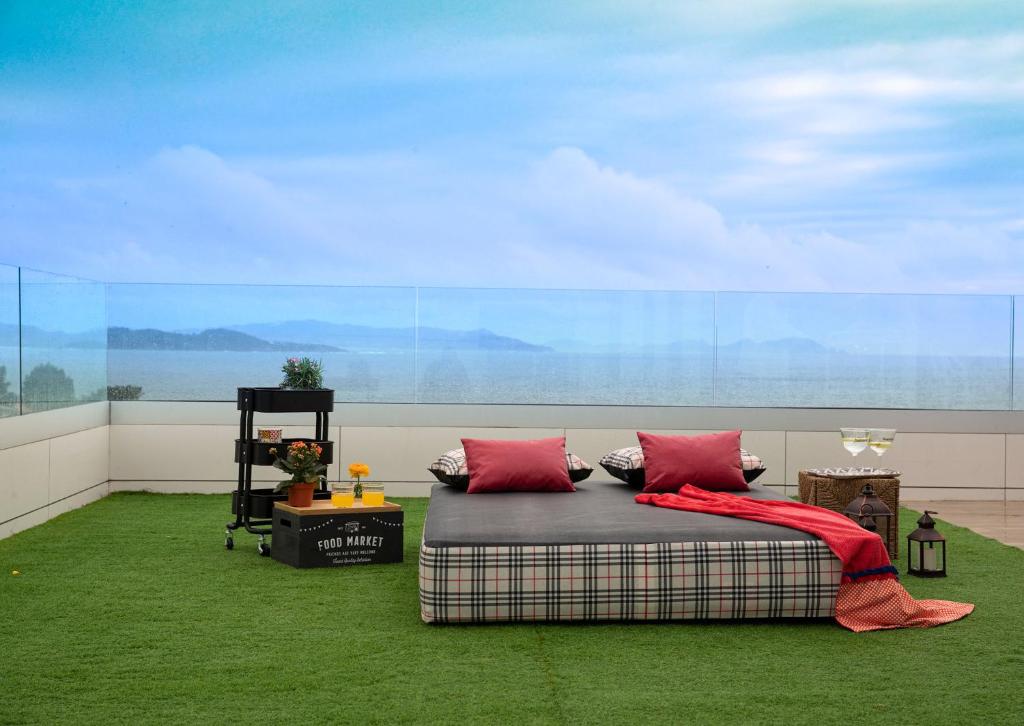 Luxury Singular Villa Canelas في سانكسينكسو: غرفة بسرير ومخدات حمراء على سجادة خضراء