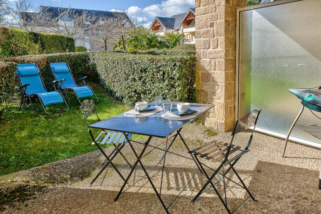 een blauwe tafel en stoelen op een patio bij Joli appartement avec terrasse a Fouesnant pour deux! in Fouesnant