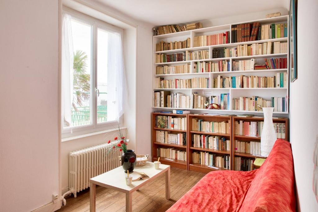 a living room with a book shelf filled with books at À 600m de la plage, maison pour 6 avec terrasse in Le Guilvinec