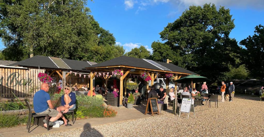 a group of people sitting in chairs under a pavilion at Glamping at Back Of Beyond Touring Park in Saint Leonards