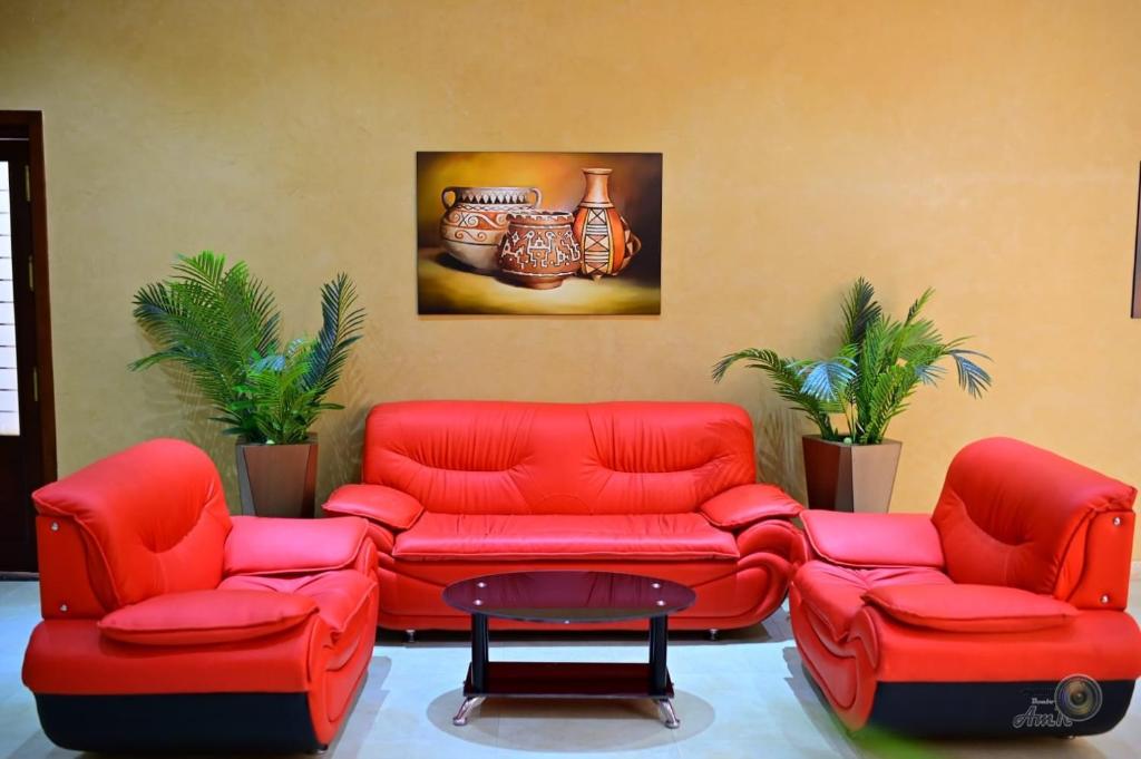 a living room with red chairs and a painting on the wall at Parrotel Lagoon Waterpark Resort in Sharm El Sheikh