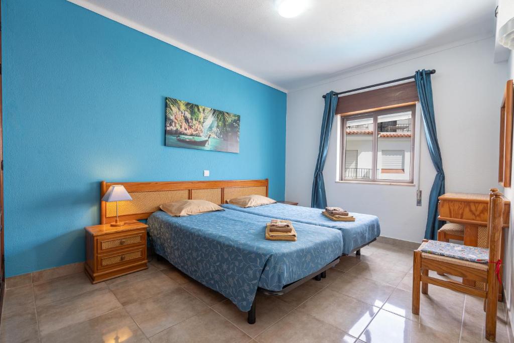 una camera blu con un letto e una finestra di Apartamentos Old Town by Umbral ad Albufeira