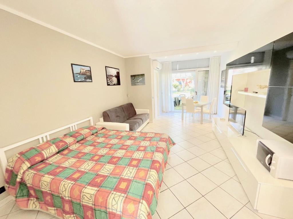 a bedroom with a bed and a living room at Premium Apartment Mono C4 in Marina di Bibbona