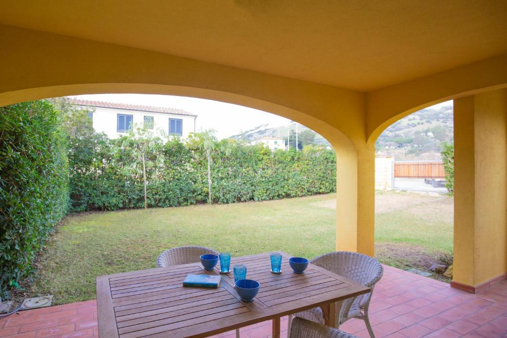 Une table et des chaises en bois sont disponibles sur la terrasse. dans l'établissement Appartamento Barbarossa by HelloElba, à Porto Azzurro