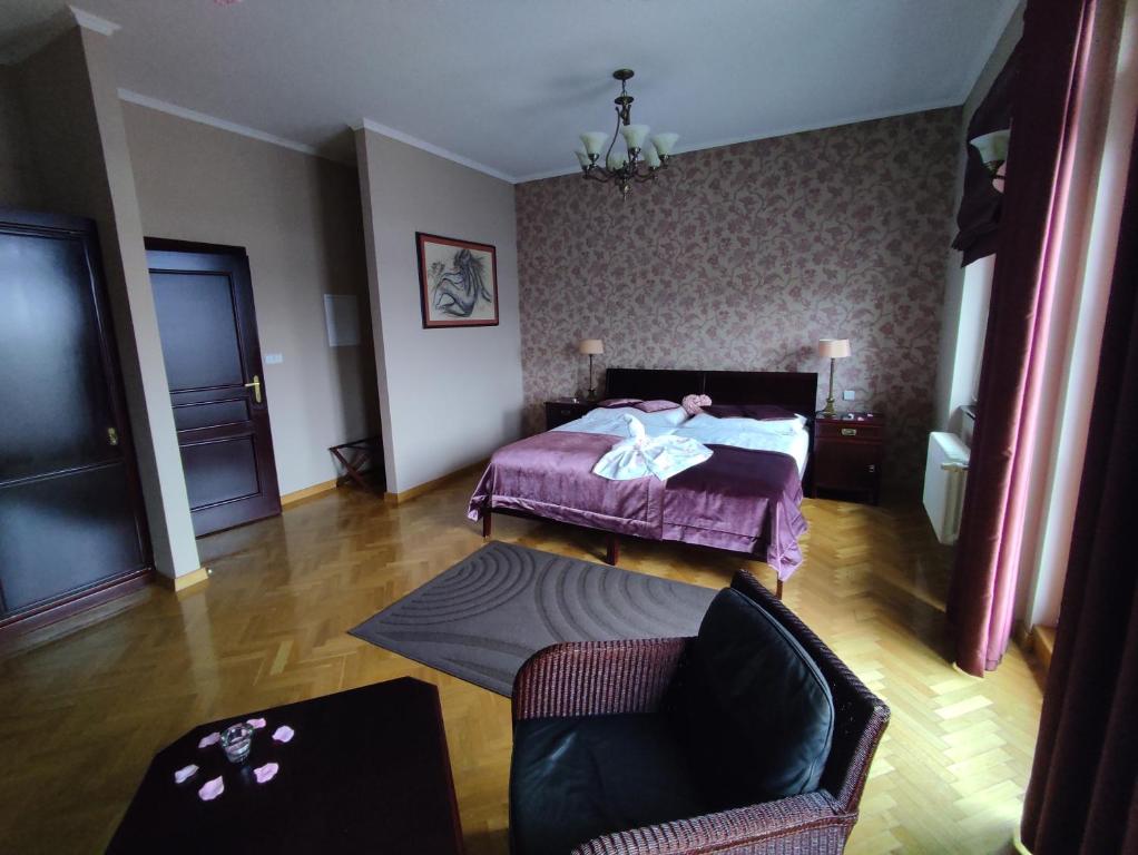 een slaapkamer met een bed, een bank en een stoel bij Rezidence Liběchov in Liběchov