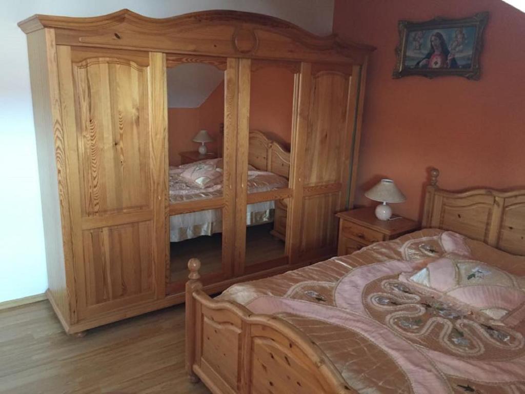 a bedroom with a large wooden bed with a dresser at Apartman u Puškina in Štrba