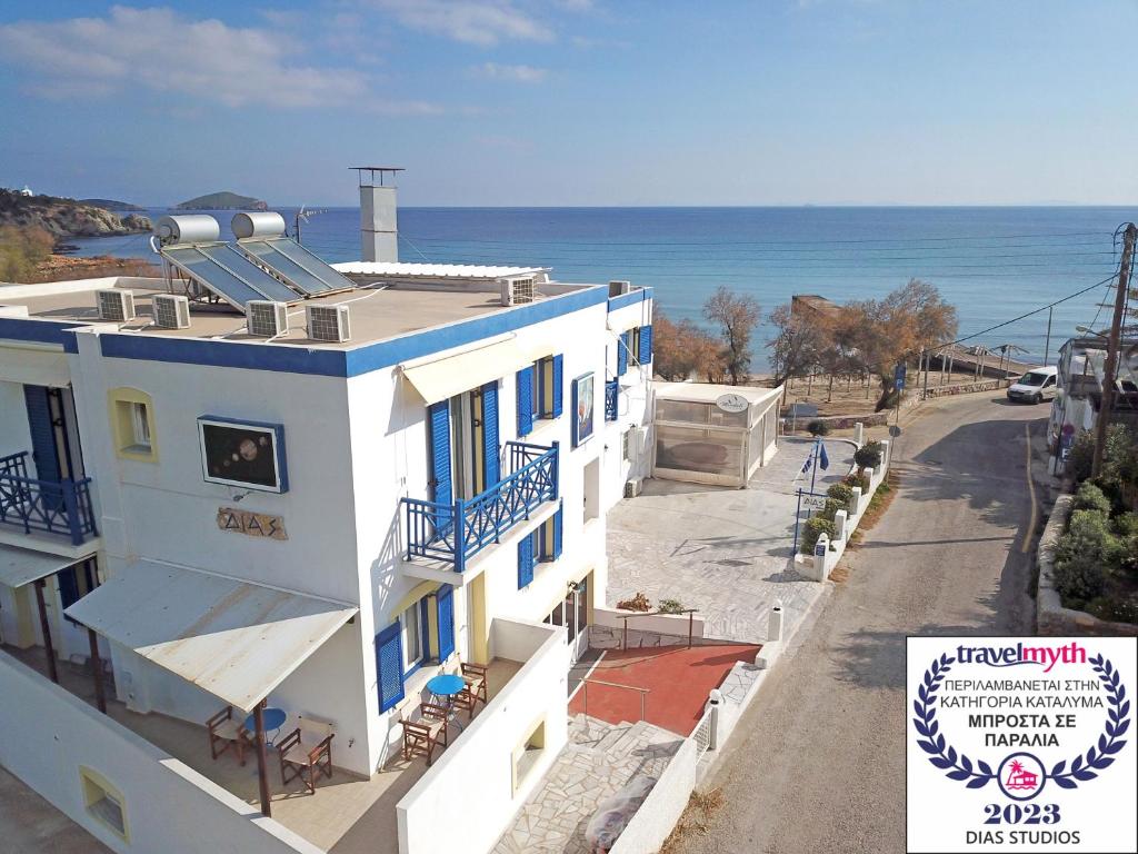 un edificio bianco con finestre blu e l'oceano di Dias Studios ad Azólimnos
