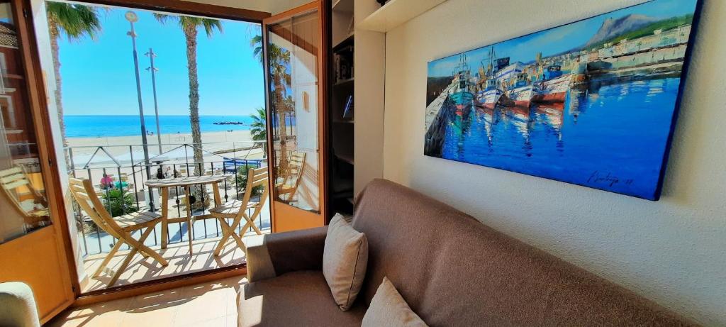 een woonkamer met een bank en uitzicht op het strand bij AR27-1 A un paso del mar in Villajoyosa