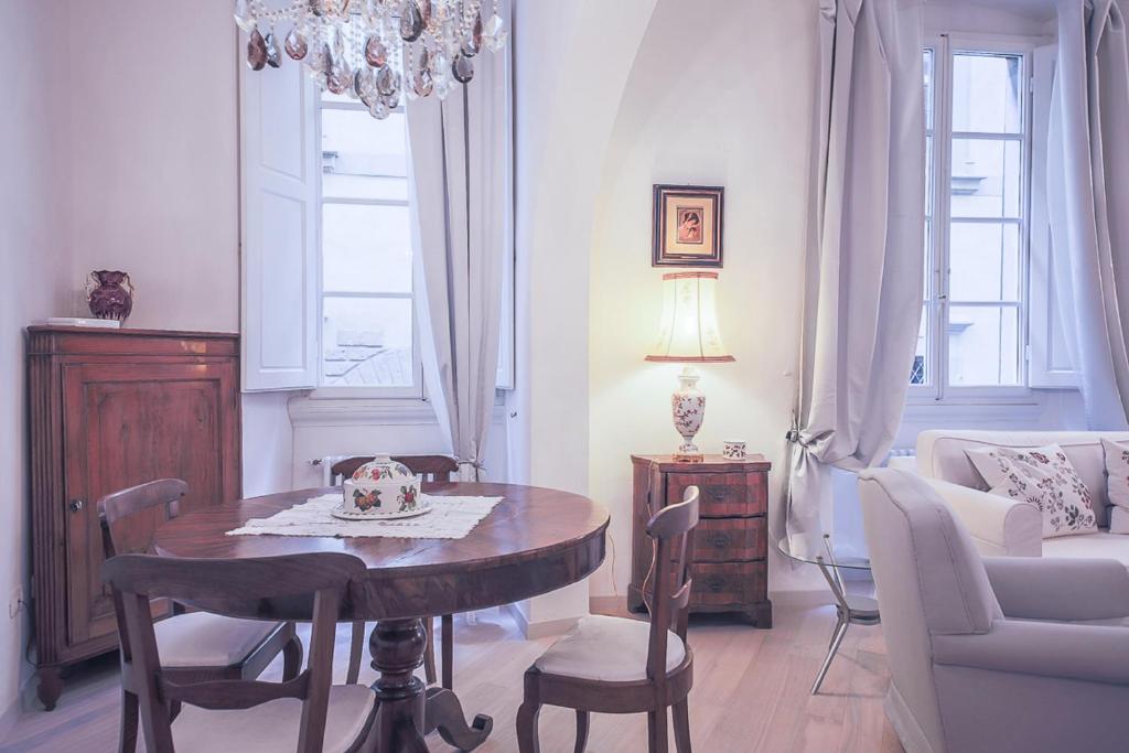 ein Wohnzimmer mit einem Tisch, Stühlen und einem Sofa in der Unterkunft Apartments Florence Parione in Florenz