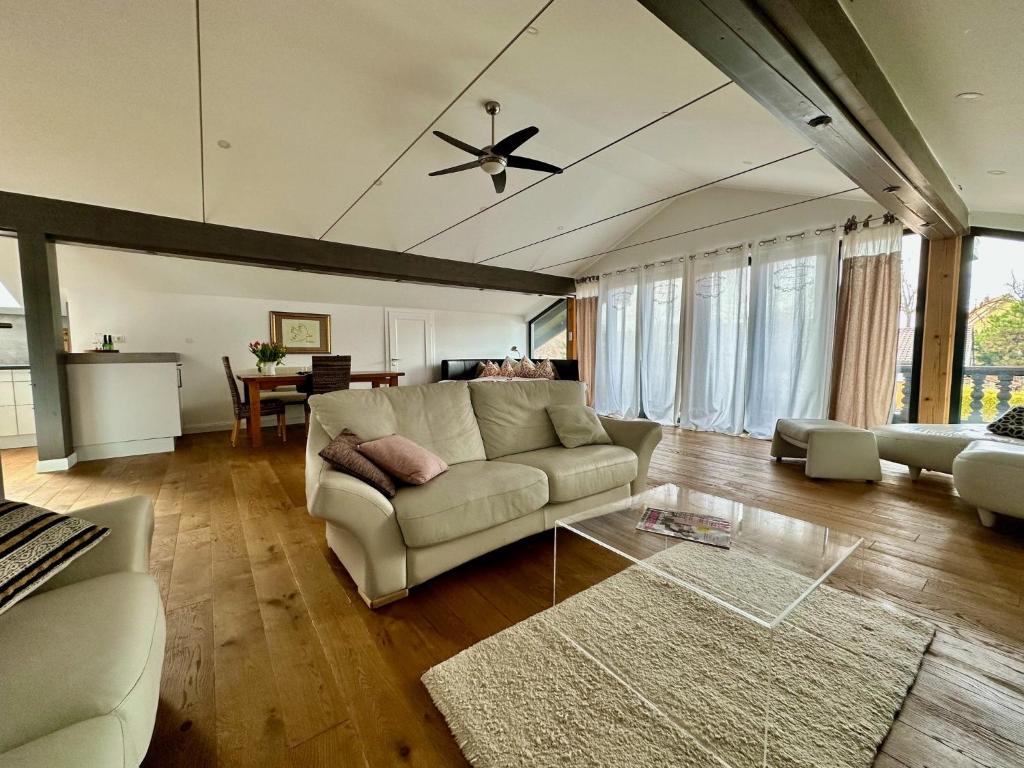 sala de estar con sofá y ventilador de techo en Appartment Via Claudia, en Schongau