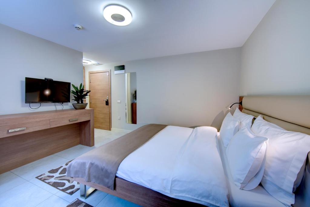 a bedroom with a large bed and a television at Hotel Srbija Garden-FREE PARKING in Belgrade