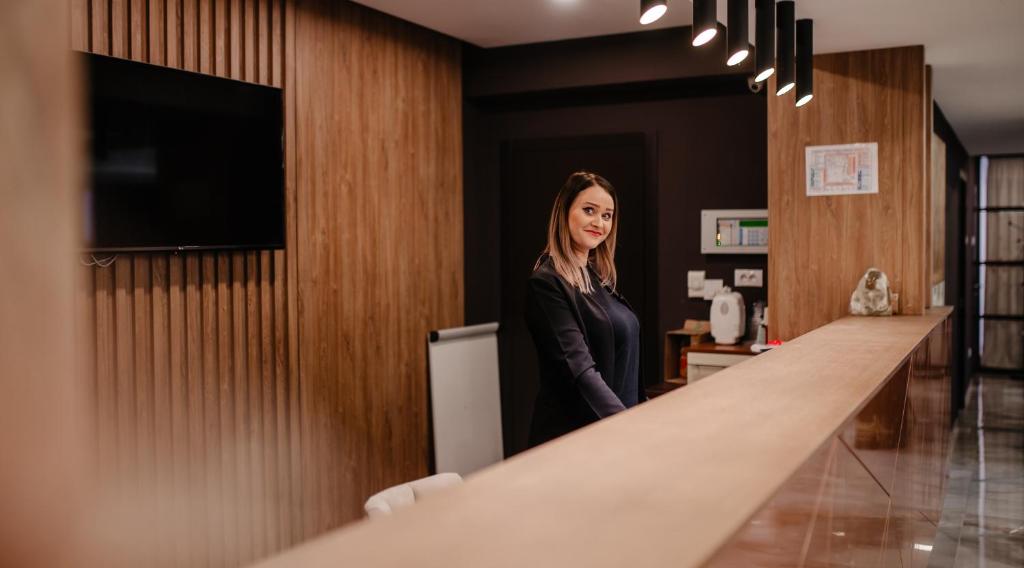 a woman standing at a counter in a room at Hotel Ariata in Scheia