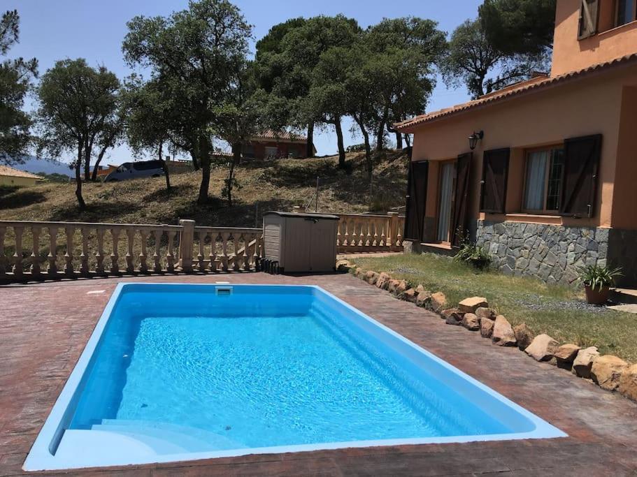 a swimming pool in front of a house at CAL XECARMA in Tordera