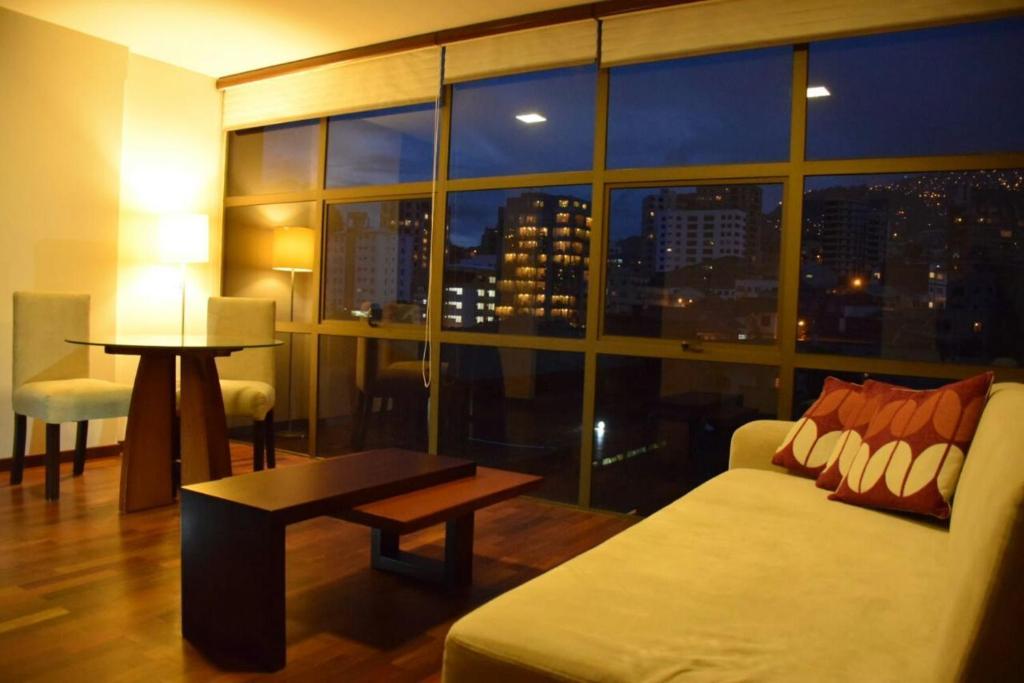 un soggiorno con divano e una grande finestra di HB Apartament Sopocachi a La Paz