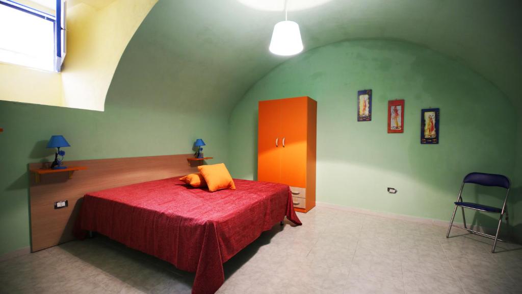 a bedroom with a red bed in a green room at Appartamento Gallipoli in Gallipoli