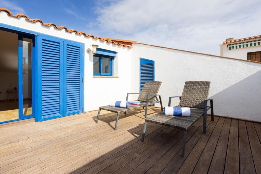 two chairs and a table on a wooden deck at Lucas House Apartments by Sitges Group in Sitges