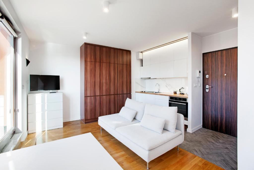 uma sala de estar com um sofá branco e uma cozinha em Marine Studio by Tyzenhauz em Gdansk