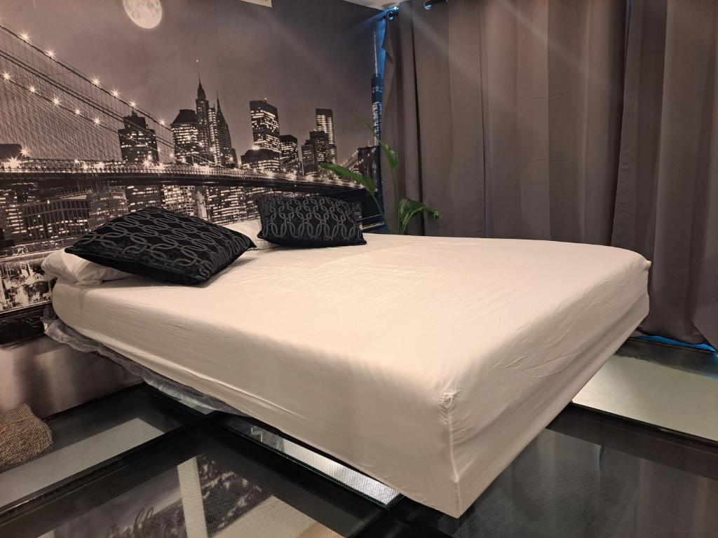 łóżko z czarnymi poduszkami w pokoju w obiekcie moraleja suite 3 w mieście Alcobendas