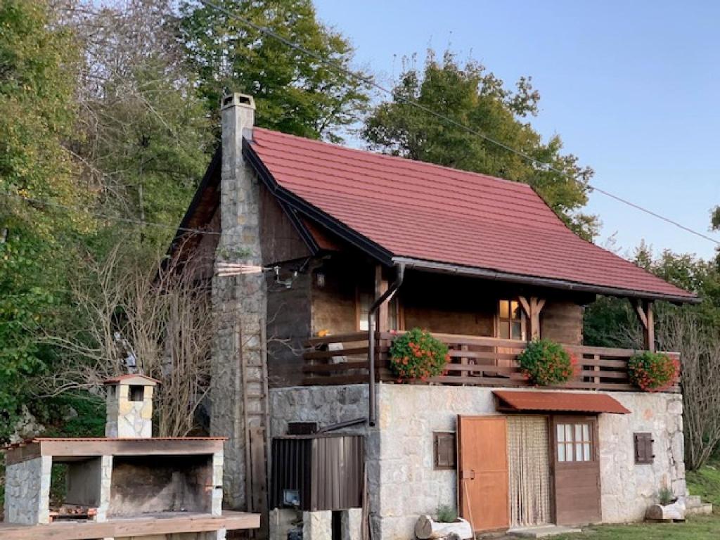 une cabane en rondins avec un toit rouge dans l'établissement Holiday Home Jela, à Gospić