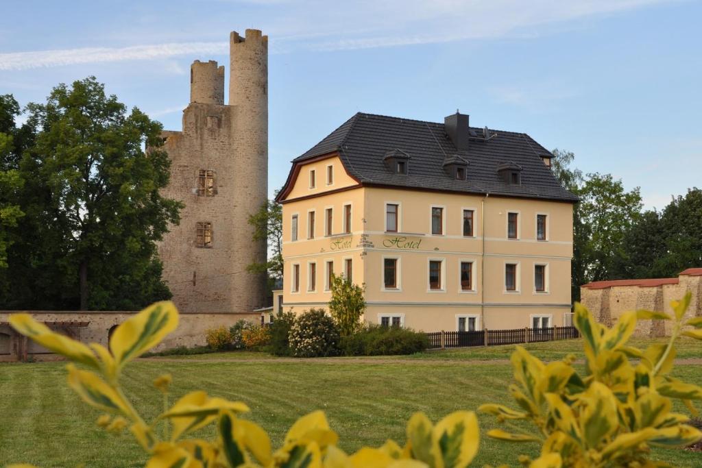 a large building with a castle in the background at Hotel Am Hohen Schwarm in Saalfeld