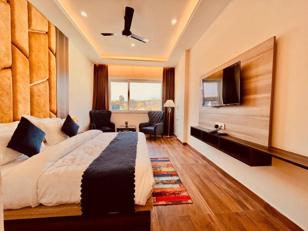 Habitación de hotel con cama y TV de pantalla plana. en Hotel Gange, Haridwar, en Haridwar