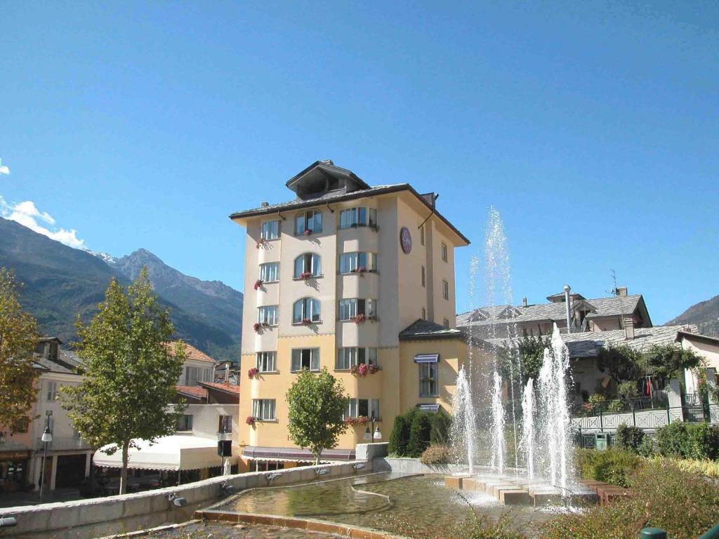 a building with a fountain in front of a building at Bijou Hotel in Saint Vincent