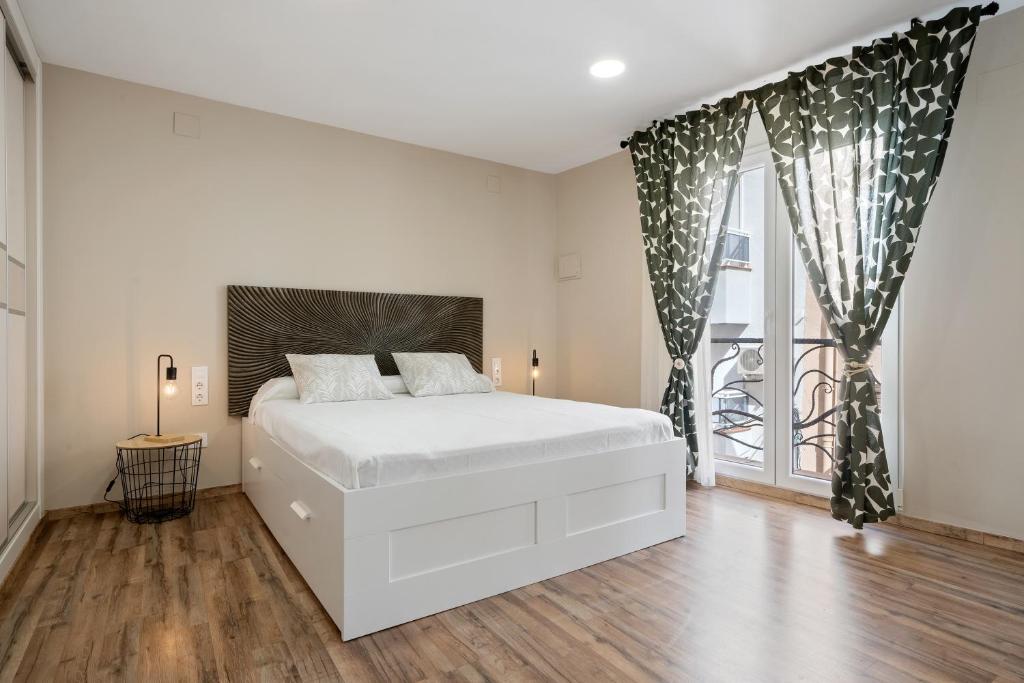 een witte slaapkamer met een bed en een raam bij Ametlla by enjoy Rocas Doradas in L'Ametlla de Mar