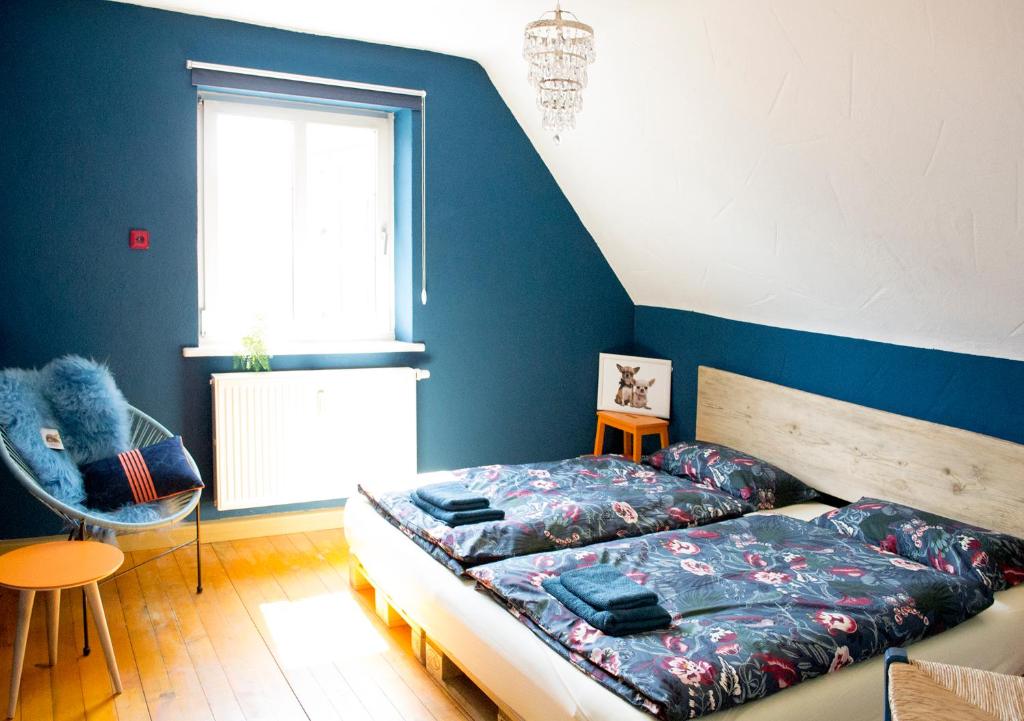 a bedroom with a bed and a blue wall at Villa Kunterbunt - sehr zentral, neu renoviert, 2SZ in Wangen im Allgäu