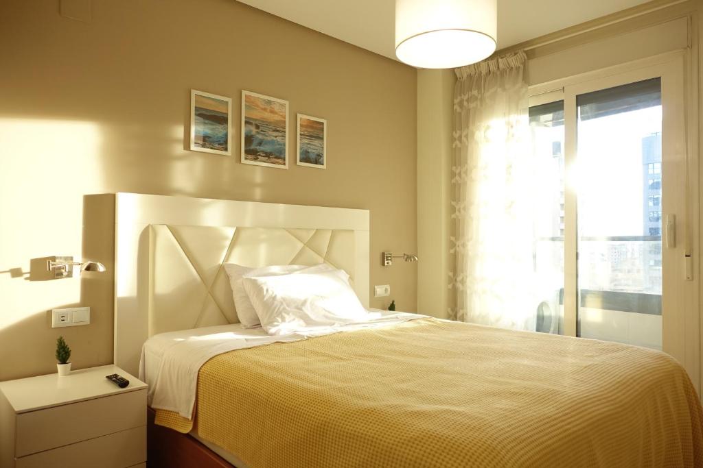 1 dormitorio con 1 cama blanca grande y ventana en The Great Valencia Stay en Valencia