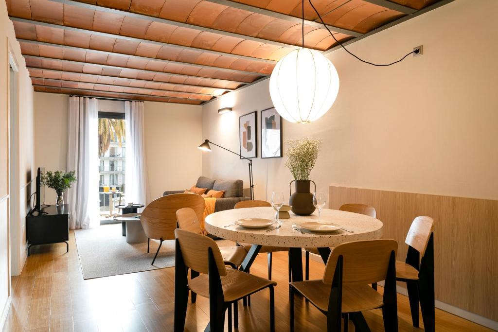 una sala da pranzo con tavolo e sedie di Aspasios Las Ramblas Apartments a Barcellona