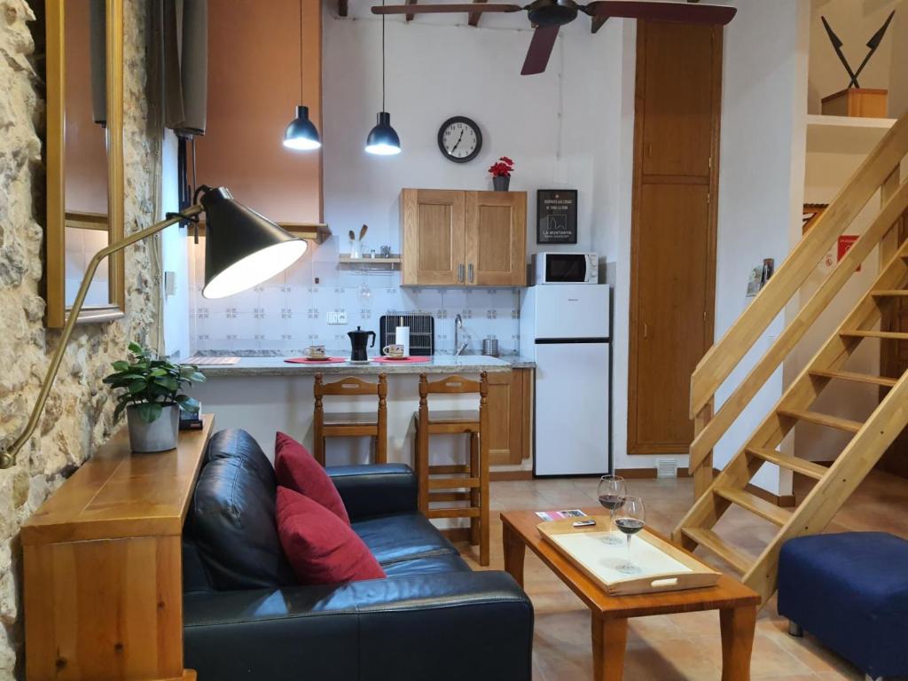 a living room with a couch and a kitchen at LA MUNTANYA - Apartamentos Rural Guadalest in Benimantell
