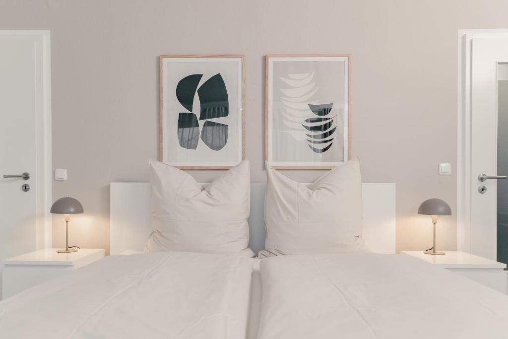 ein Schlafzimmer mit einem Bett mit zwei Bildern an der Wand in der Unterkunft Soulplace Gelsenkirchen - stilvoll & gemütlich in Gelsenkirchen