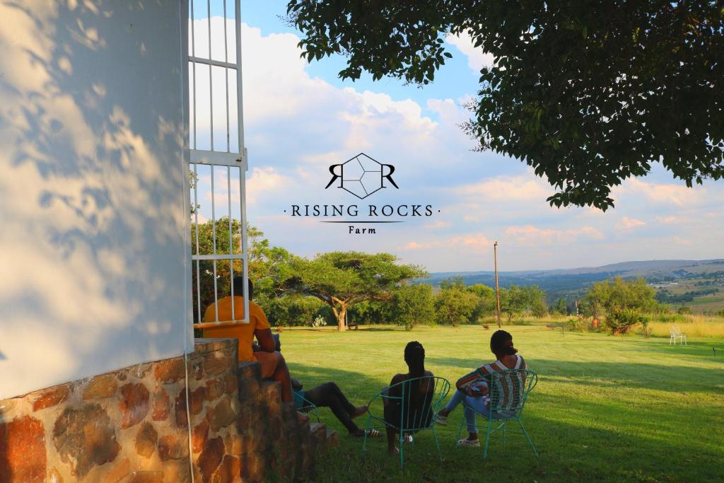 un grupo de tres mujeres sentadas en sillas en un campo en Relaxing Mountain FarmStay w hikes, boma, pool, en Magaliesburg