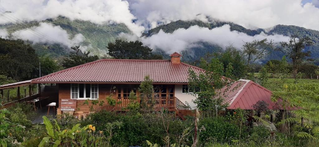 BaezaにあるPosada Campo Libreの山を背景にした木造家屋