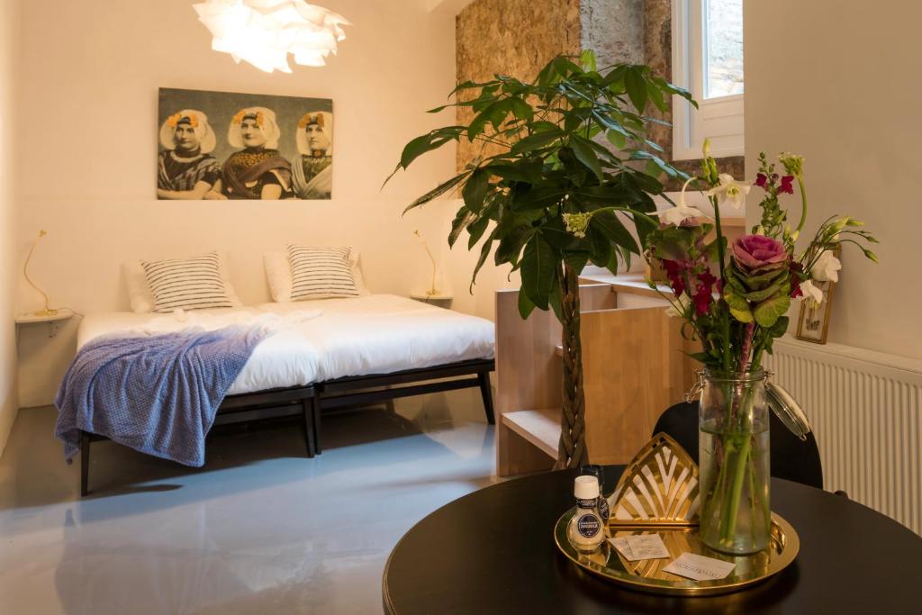 Hotel Zilt Studio's في فليسنجن: غرفة بسرير وطاولة مع ورد