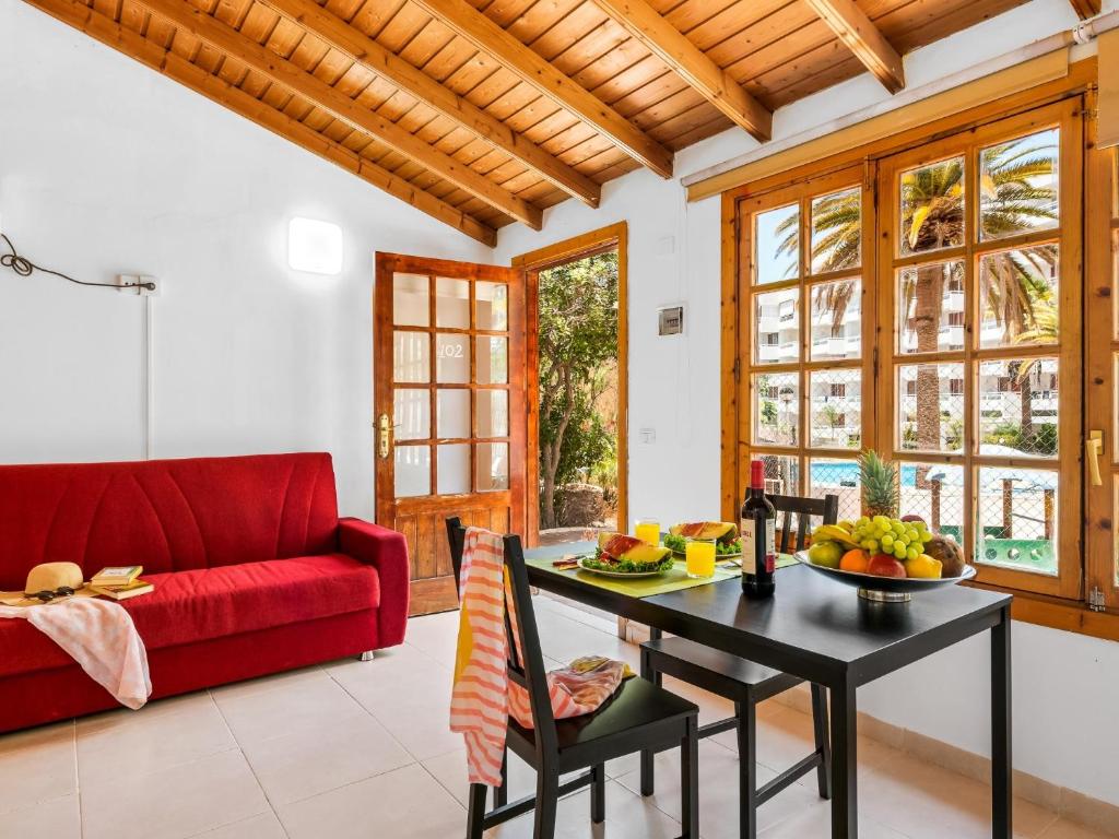 una sala de estar con un sofá rojo y una mesa con fruta. en 102 Bright Accomodation with Pool View, en Adeje