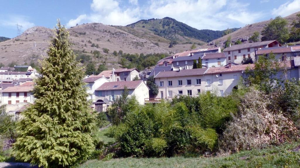 um grupo de edifícios numa cidade com montanhas em Gîte le Marmare em Caussou