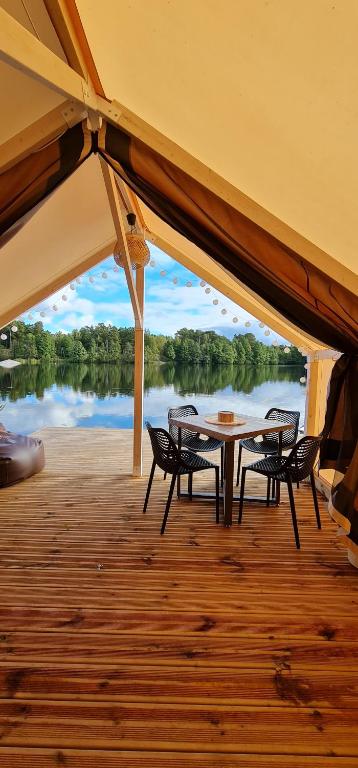 a patio with a table and chairs on a boat at BB camping in Liepāja