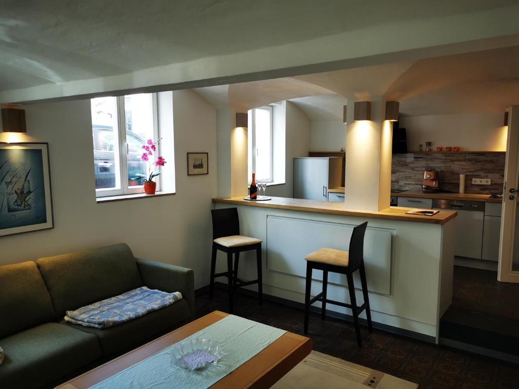 a living room with a couch and a kitchen at Drachenhöhle in Oldenburg