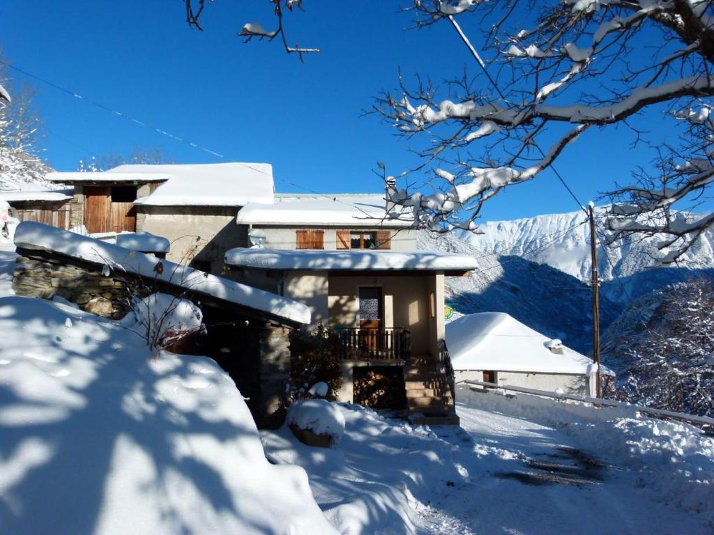 ein schneebedecktes Haus vor der Tür in der Unterkunft La Grange in Condamine-Châtelard
