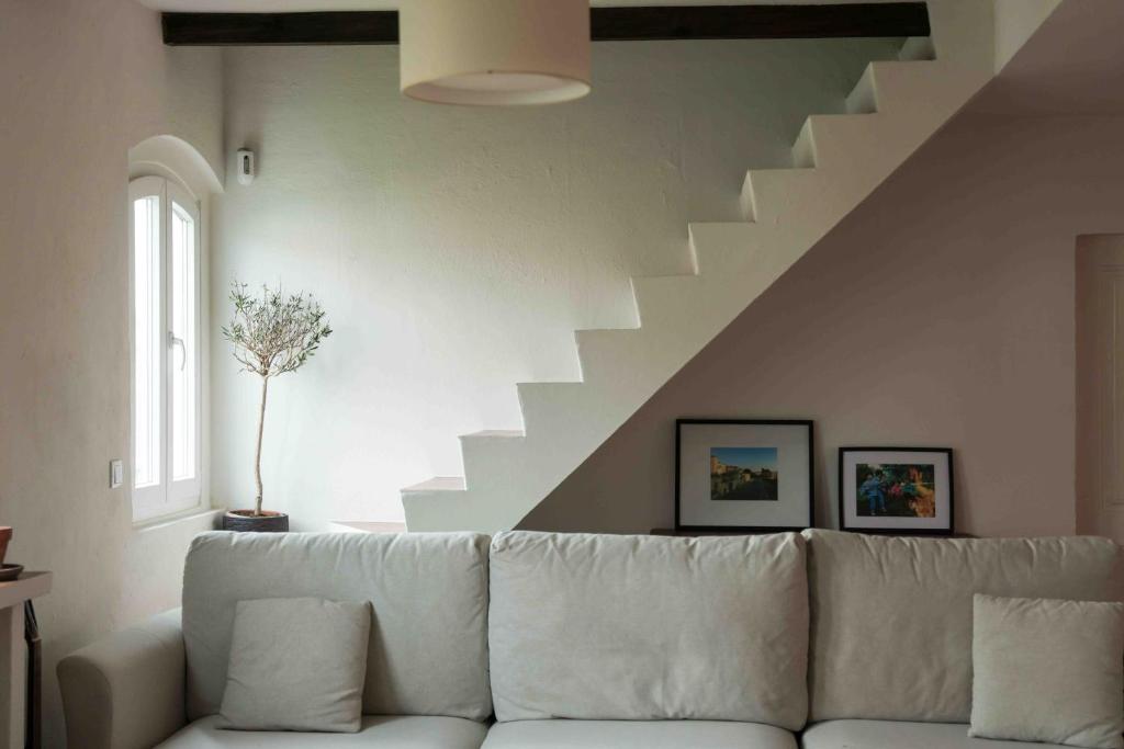 ein weißes Sofa im Wohnzimmer mit einer Treppe in der Unterkunft Quintinha a 35min de Lisboa in Mafra