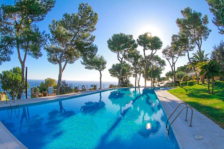 a large swimming pool with a view of the ocean at Club Villamar - El Far in Llafranc