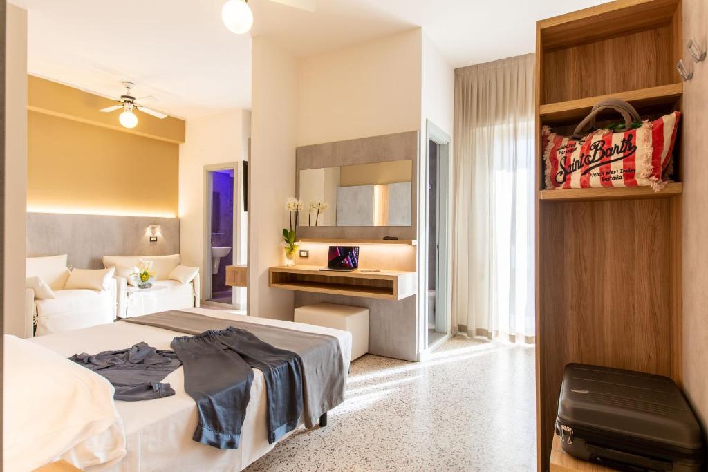 ガビッチェ・マーレにあるHotel Romanticoのベッドとデスクが備わるホテルルームです。