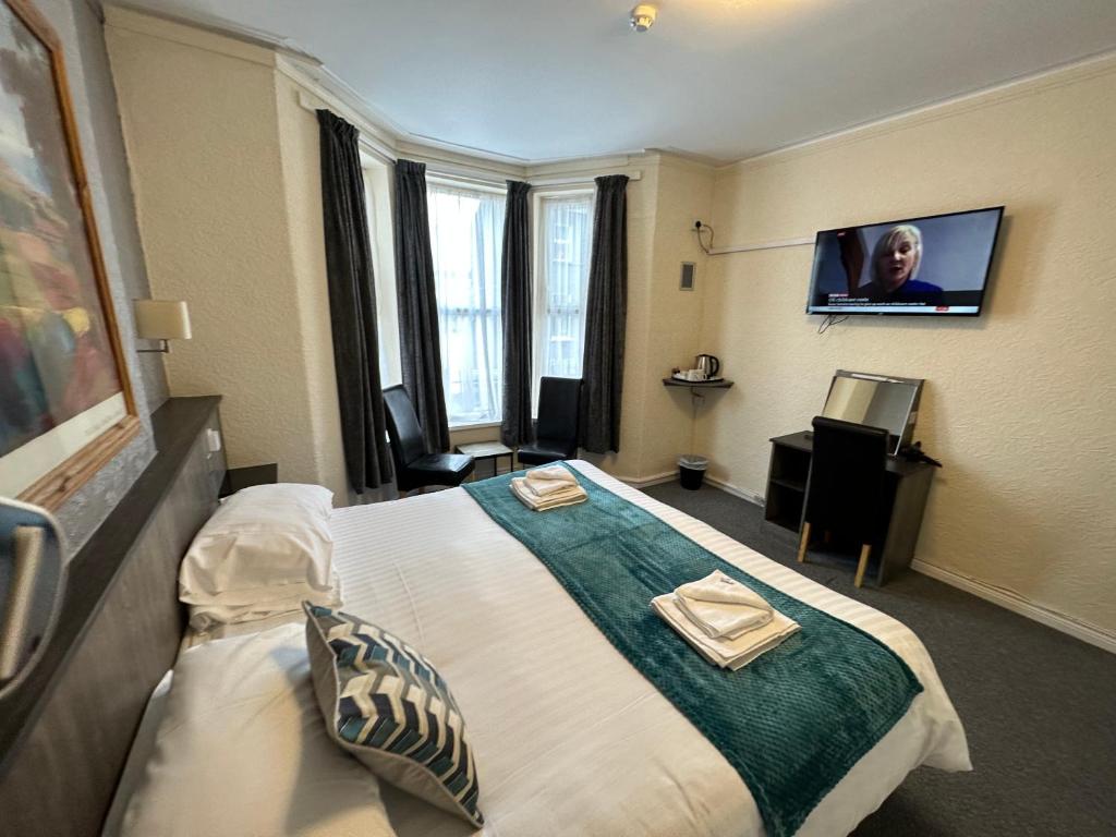 a hotel room with a bed and a flat screen tv at The Port Hotel in Portrush