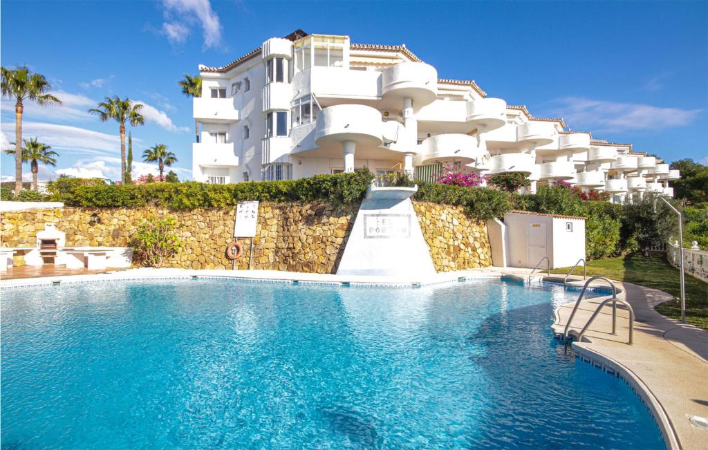 ミハス・コスタにあるAmazing Apartment In Mijas Costa With Outdoor Swimming Poolの建物の前にスイミングプールがあるホテル