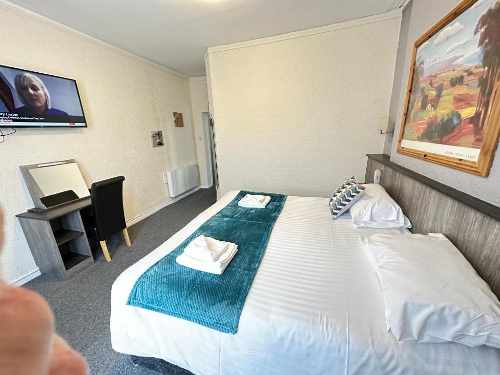 a hotel room with a bed and a desk at The Port Hotel in Portrush