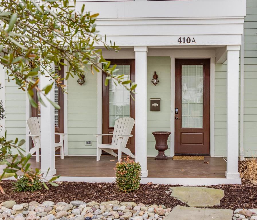 a white house with a front porch with a wooden door at 410A The Jetty House in Virginia Beach